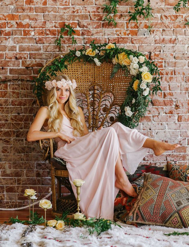 Photo via Joanna August - A bohemian bride in a hand-carved Victorian loveseat may look unusual, but place the barefoot beauty in a rattan peacock chair dripping with greenery and blossoming white and yellow blooms and her playfulness is captured!