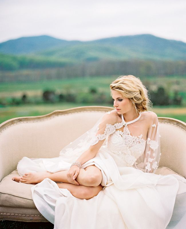 Photo by Eric Kelley Photography - One of the ways this pose works is by removing the bride from the excitement and allowing her to breathe. This thoughtful bride, who is (seemingly) candidly resting shoeless and curled up in her dress on a soft sofa overlooking the land is just divine.