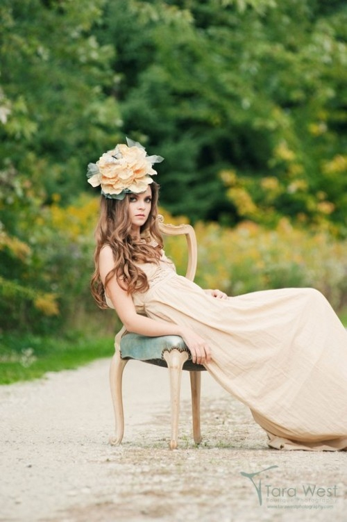 Photo by Tara West Photography via Blair Nadeau Millinery - Channeling her inner flower child, this bride’s effortlessly stunning pose in the center of a dirt road seems to say, “going my way?” Her wild locks, oversized floral headdress, and natural-colored cloth dress add a sense of whimsical 1960s wonder.