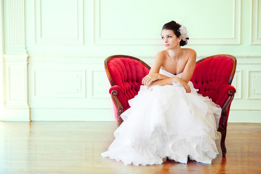 Photo via Skyla Arts - Taking advantage of an empty corner adds the contrast one needs to capture this classic photograph. From the red tufted loveseat placed away from the wall, to the white tulle of the bride’s dress, and from the pale mint-green molding of the great wall, to the polished wood floors, each contrasting color and pattern plays an integral role in highlighting her beauty.